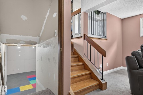 Hardwood staircase with black metal balusters and wood handrail - 14612 29 Street Nw, Edmonton, AB 