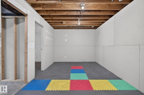 Unfinished basement room featuring exposed ceiling joists, recessed lighting, and drywall-paneled walls - 14612 29 Street Nw, Edmonton, AB 