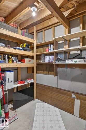 Functional storage area featuring exposed wood ceiling beams and multiple shelving units - 14612 29 Street Nw, Edmonton, AB 
