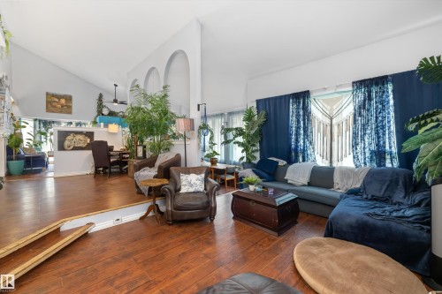 Spacious living area featuring wood-finish flooring, vaulted ceilings, and large windows - 7 53424 Range Road 13, Rural Parkland County, AB 