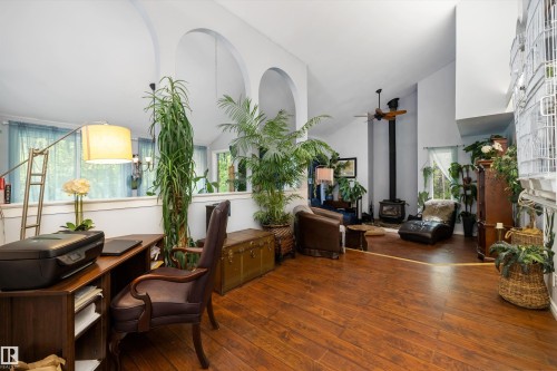 Open-concept interior featuring wood-finish flooring, vaulted ceilings, and architectural archways - 7 53424 Range Road 13, Rural Parkland County, AB 