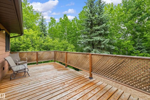 Expansive outdoor deck featuring wood plank flooring and a lattice railing - 7 53424 Range Road 13, Rural Parkland County, AB 