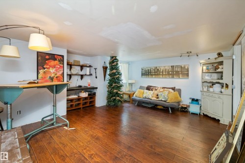 Spacious interior featuring wood-finish flooring, light-colored walls, and a built-in shelving unit - 7 53424 Range Road 13, Rural Parkland County, AB 