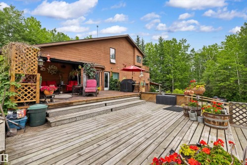 Multi-level wood decking with broad steps and a covered outdoor living area - 7 53424 Range Road 13, Rural Parkland County, AB 