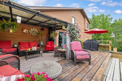 Spacious wood-finish deck featuring a covered patio area with a translucent roof - 7 53424 Range Road 13, Rural Parkland County, AB 