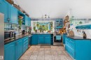 Kitchen with bright blue cabinetry and dark countertops - 7 53424 Range Road 13, Rural Parkland County, AB 