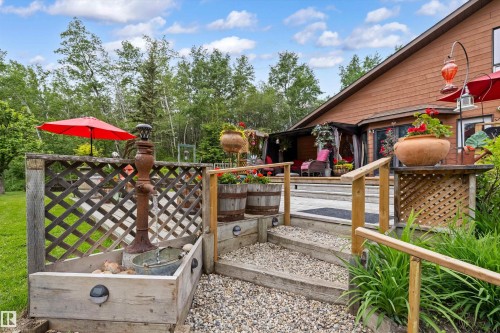 Multi-level exterior deck featuring wood railing and gravel steps - 7 53424 Range Road 13, Rural Parkland County, AB 