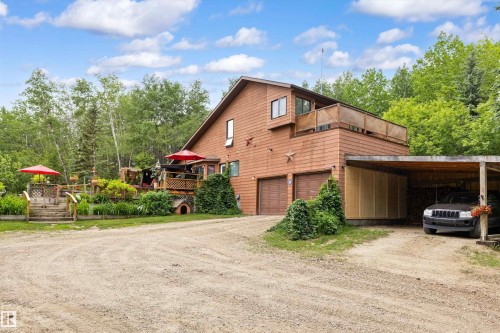 Two-story residence featuring wood-paneled siding and a gravel driveway - 7 53424 Range Road 13, Rural Parkland County, AB 