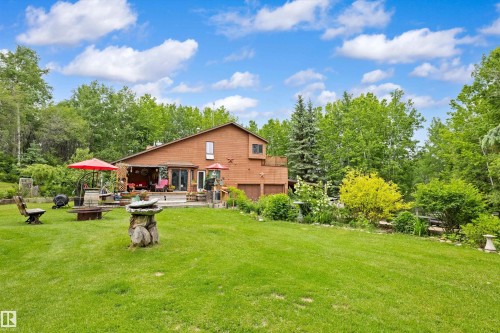 Expansive grassy lawn with a terraced deck and patio - 7 53424 Range Road 13, Rural Parkland County, AB 