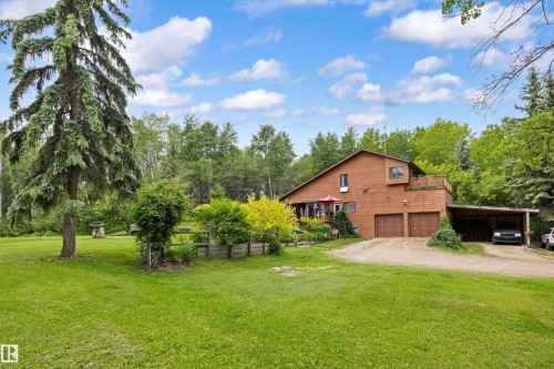Wood-sided residence featuring a two-car garage, an attached carport, and an upper-level deck - 7 53424 Range Road 13, Rural Parkland County, AB 