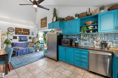 Combined kitchen and living space featuring a vaulted ceiling with a ceiling fan, recessed lighting, tile flooring, stainless steel appliances, and a patterned tile backsplash - 7 53424 Range Road 13, Rural Parkland County, AB 