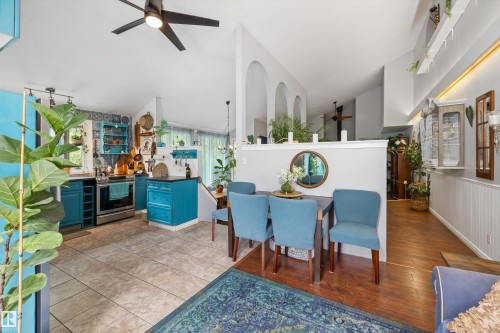 Open-concept kitchen and dining area featuring tile flooring, stainless steel appliances, and a vaulted ceiling - 7 53424 Range Road 13, Rural Parkland County, AB 