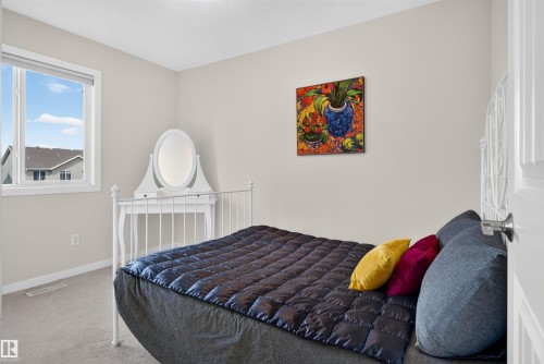 Bright interior room featuring a window with a white frame, light-toned carpeting, and neutral wall paint - 6928 22 Avenue, Edmonton, AB 