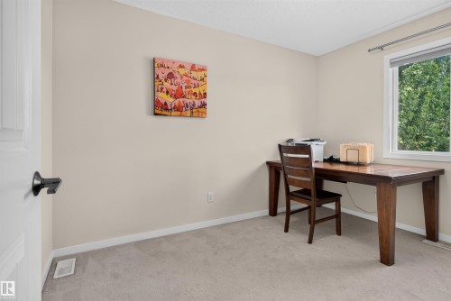 Carpeted room featuring a white-framed window, light-toned walls, and white trim - 6928 22 Avenue, Edmonton, AB 