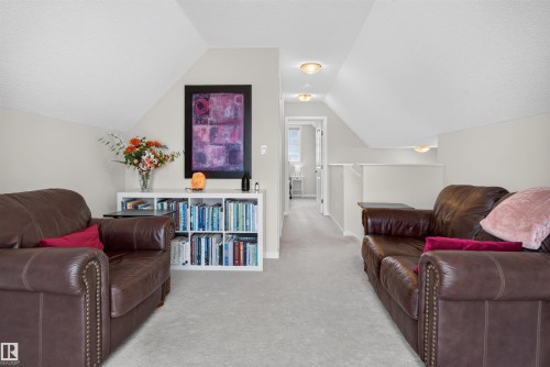 Attic lounge space featuring sloped ceilings, recessed lighting, and light gray wall-to-wall carpeting - 6928 22 Avenue, Edmonton, AB 