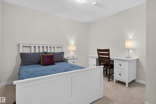 Neutral-toned bedroom with textured carpeting and a white ceiling - 6928 22 Avenue, Edmonton, AB 