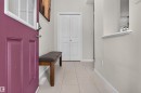 Entryway featuring a panel door with an upper glass insert, tile flooring, and white baseboards - 6928 22 Avenue, Edmonton, AB 
