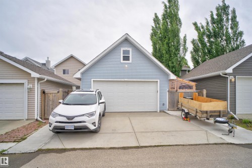 Light blue siding garage with a white overhead door and attic window - 6928 22 Avenue, Edmonton, AB 