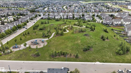 Expansive green space featuring a playground area and paved walking paths - 6928 22 Avenue, Edmonton, AB 