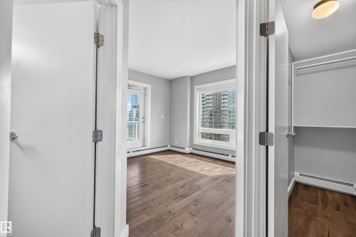 Bedroom featuring wood-finish flooring, light grey painted walls, and white trim - 2902 10152 104 Street, Edmonton, AB 