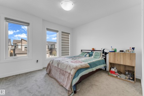 Carpeted room featuring multiple windows, white walls, and a flush mount ceiling light - 432 29 Street, Edmonton, AB 