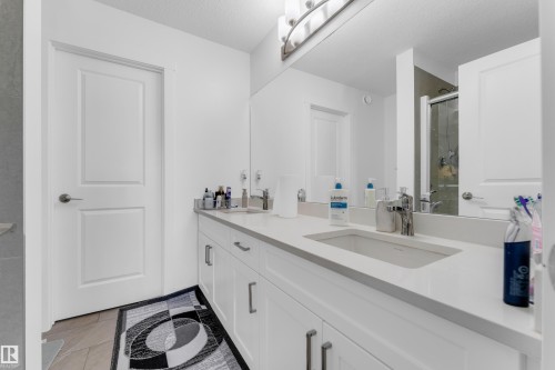 Spacious bathroom vanity featuring a light-toned countertop, undermount sink, and contemporary chrome faucet - 432 29 Street, Edmonton, AB 