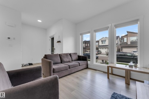 Bright living area featuring wood-finish flooring, recessed ceiling lighting, and a white interior color palette - 432 29 Street, Edmonton, AB 