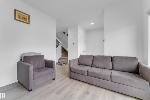 Living area featuring light-tone wood-finish flooring and white walls - 432 29 Street, Edmonton, AB 