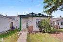 Front exterior with light-colored siding and a contrasting dark green roof trim - 3704 39 Avenue, Edmonton, AB 
