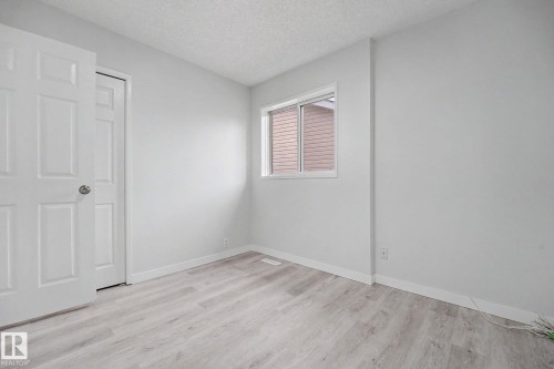 Light wood-finish flooring complements neutral wall tones and a textured ceiling - 3704 39 Avenue, Edmonton, AB 