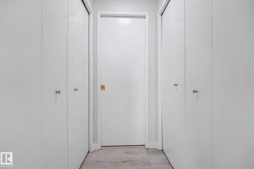 Hallway featuring light-toned flooring, white walls, and bright overhead lighting - 3704 39 Avenue, Edmonton, AB 
