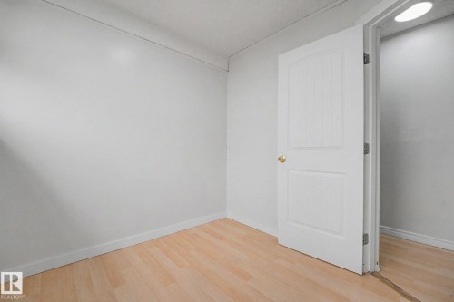 Light wood-finish flooring with white baseboards and neutral wall tones - 3704 39 Avenue, Edmonton, AB 