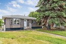 Ranch-style residence featuring vertical siding, a bay window, and a gabled roof - 6404 88 Avenue, Edmonton, AB 