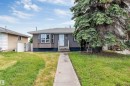 Ranch-style residence featuring vertical siding, a bay window, and a gabled roof - 6404 88 Avenue, Edmonton, AB 