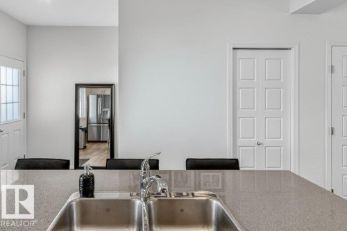 Dual-basin stainless steel sink with a chrome faucet set into a speckled countertop - 3708 42 Avenue, Beaumont, AB 