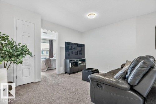 Neutral tone wall paint, light gray carpeting, flush mount ceiling light fixture, and a white interior door with paneling - 3708 42 Avenue, Beaumont, AB 