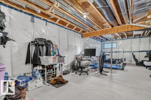 Unfinished basement with concrete flooring and exposed ceiling joists, featuring an insulated perimeter and a horizontal window - 3708 42 Avenue, Beaumont, AB 