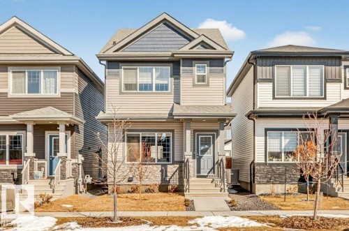Contemporary two-story residence featuring a gray and beige siding exterior with stone accents - 3708 42 Avenue, Beaumont, AB 
