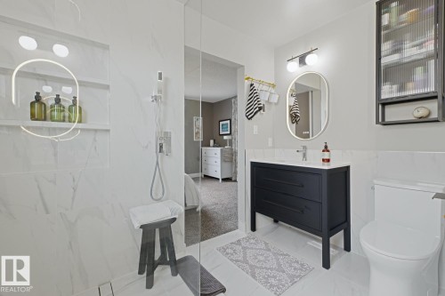 Modern bathroom featuring a glass-enclosed shower with a built-in niche and recessed lighting - 3504 102 Avenue, Edmonton, AB 
