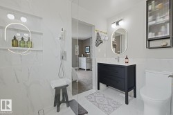 Modern bathroom featuring a glass-enclosed shower with a built-in niche and recessed lighting - 
