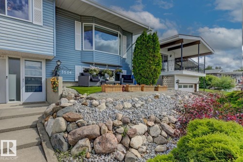 Light blue siding exterior featuring white trim windows and a bay window - 3504 102 Avenue, Edmonton, AB 
