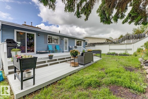 Rear exterior showcasing a multi-level deck with white railings, a sliding glass door, and a separate entry door - 3504 102 Avenue, Edmonton, AB 
