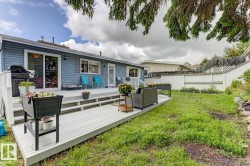 Rear exterior showcasing a multi-level deck with white railings, a sliding glass door, and a separate entry door - 