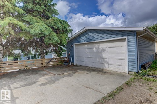 Detached garage with blue siding and white panel garage door - 3504 102 Avenue, Edmonton, AB 