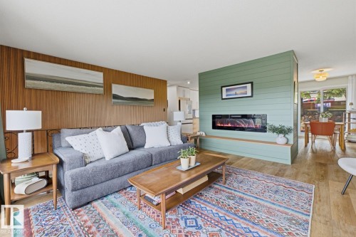 Living area featuring a floor-to-ceiling accent wall with wood paneling - 3504 102 Avenue, Edmonton, AB 
