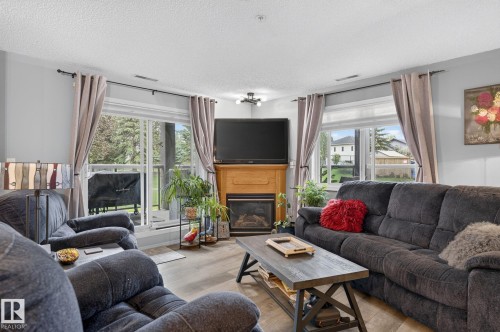 Spacious living area featuring light gray walls and wood-finish flooring - 122 279 Suder Greens Drive, Edmonton, AB 