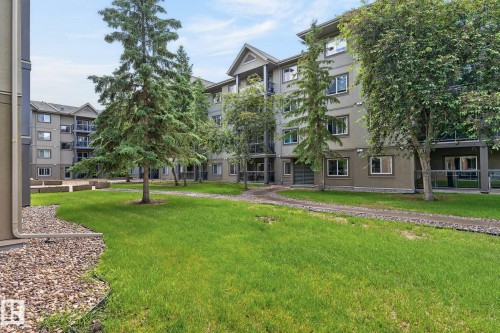 Central green space surrounded by multi-story residential buildings - 122 279 Suder Greens Drive, Edmonton, AB 