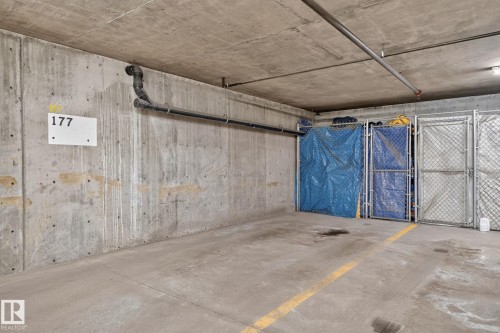 Dedicated parking space featuring a concrete floor with painted yellow lines - 122 279 Suder Greens Drive, Edmonton, AB 