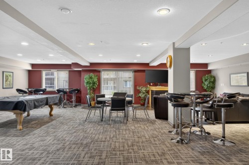 Spacious common area featuring patterned carpeting, recessed lighting, and accent walls - 122 279 Suder Greens Drive, Edmonton, AB 