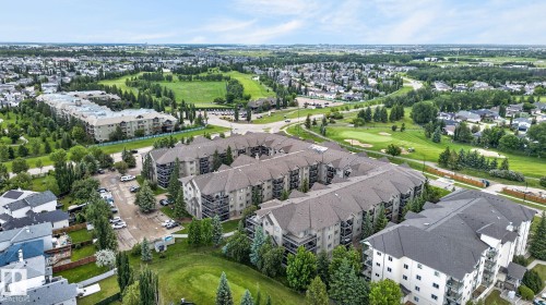 Large residential complex featuring multiple buildings with private balconies and surface parking - 122 279 Suder Greens Drive, Edmonton, AB 